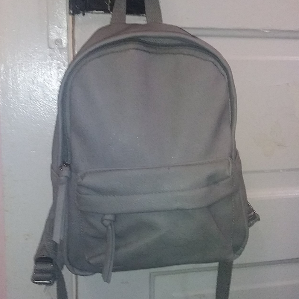 A plain grey small backpack purse
